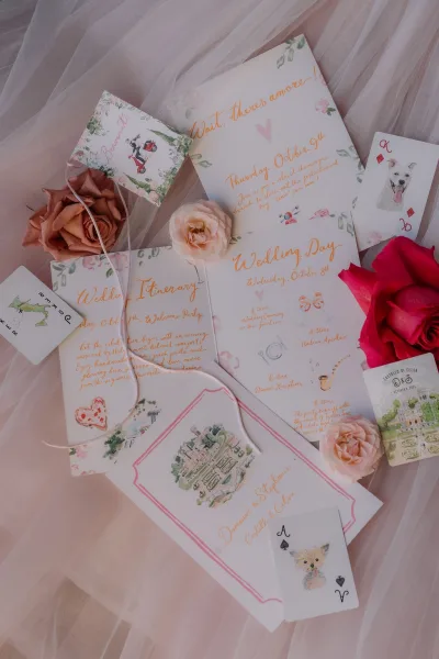 Wedding invitation suite featuring watercolor wedding invitations, styled with playing cards on soft tulle.
